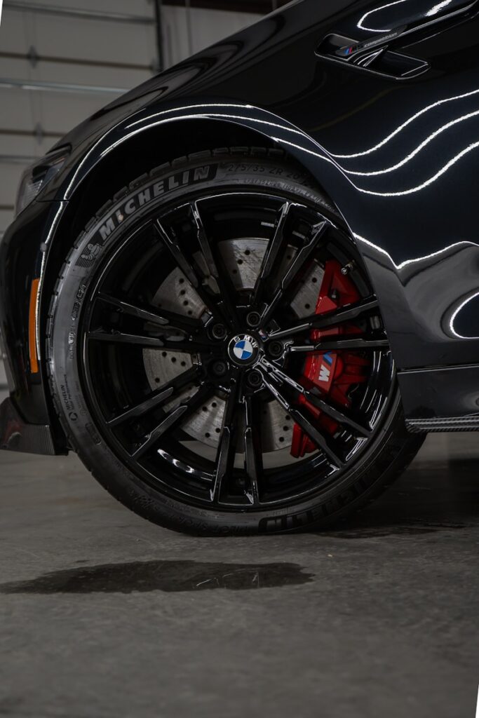 a close up of a black car with red spokes